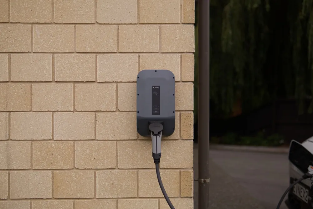 Wall-mounted electric vehicle charger on a brick wall