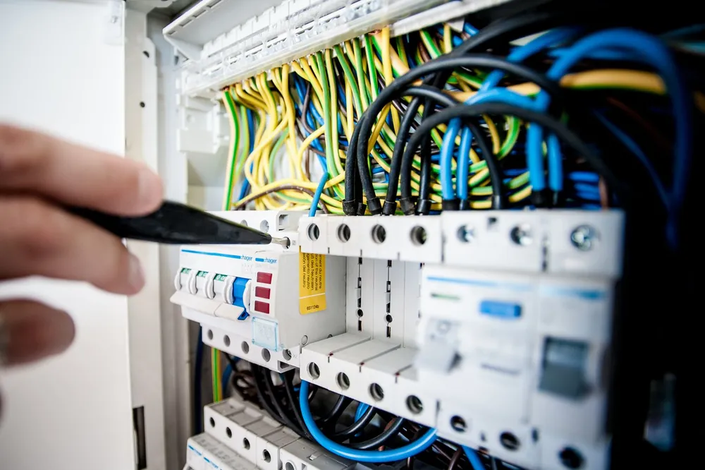 Close-up of an electrician working on a switchboard full of new safety switches